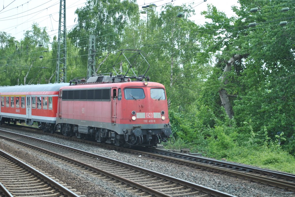 Am 28.4.2011 zieht 110 410-8 einen Regionalexpress durch Dsseldorf Volksgarten.